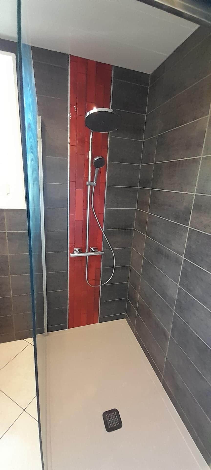 Douche de plain-pied sur receveur extra-plat, faïence anthracite et bande de carrelage rouge, par AML Plomberie