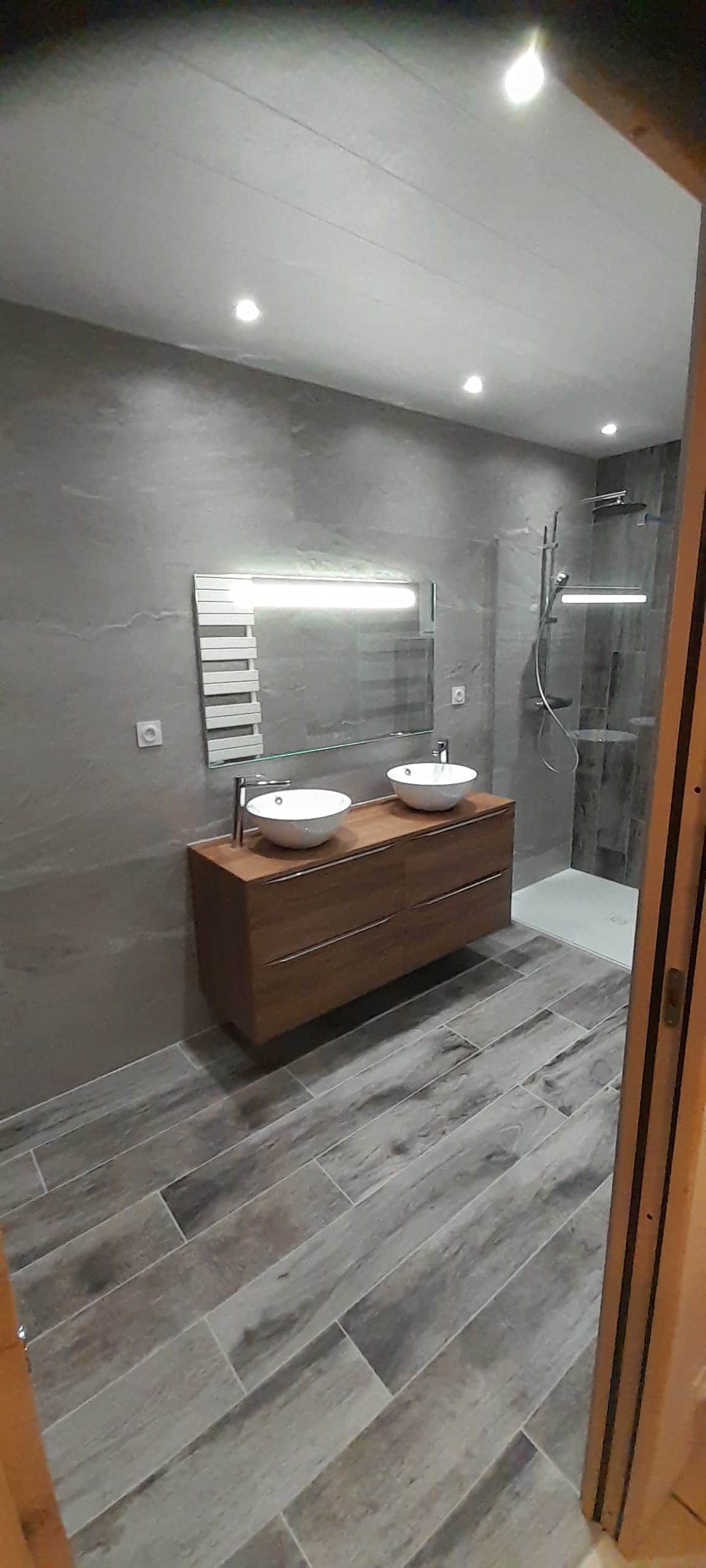 Salle de bain clé en main : deux vasques à poser sur meuble bois suspendu, miroir lumineux et douche vitrée